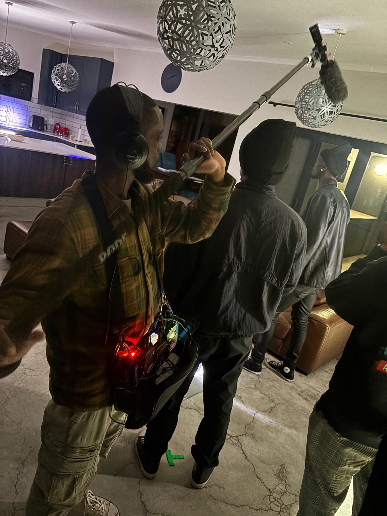 Boom operator capturing audio during a night interior production
